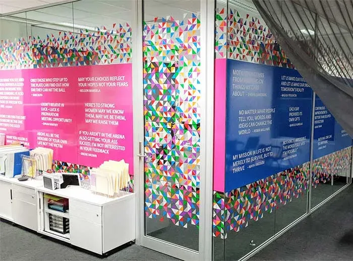 Printed vinyl graphics with brand colours and text applied to glass office partitions in Dubai