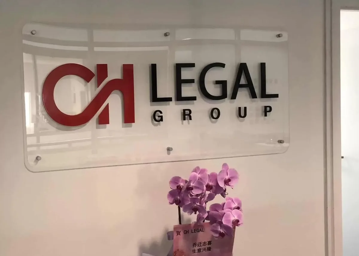 Office reception logo with red and black 3D letters on a clear acrylic panel standing off the wall