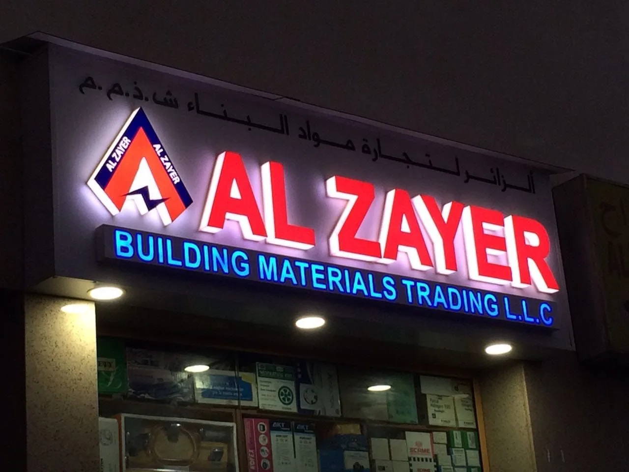 Front-lit 3D letters and logo installed on a building materials shop fascia at night