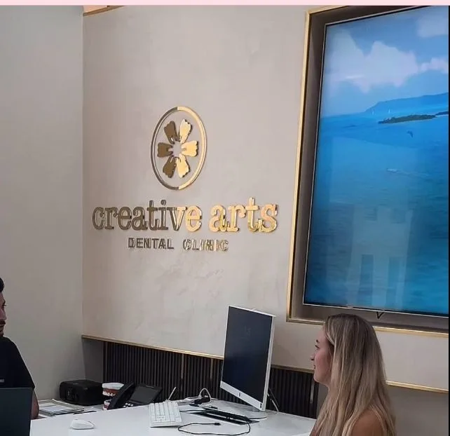 Gold 3D logo fixed to a clinic reception wall, a typical centrepiece of interior wall branding