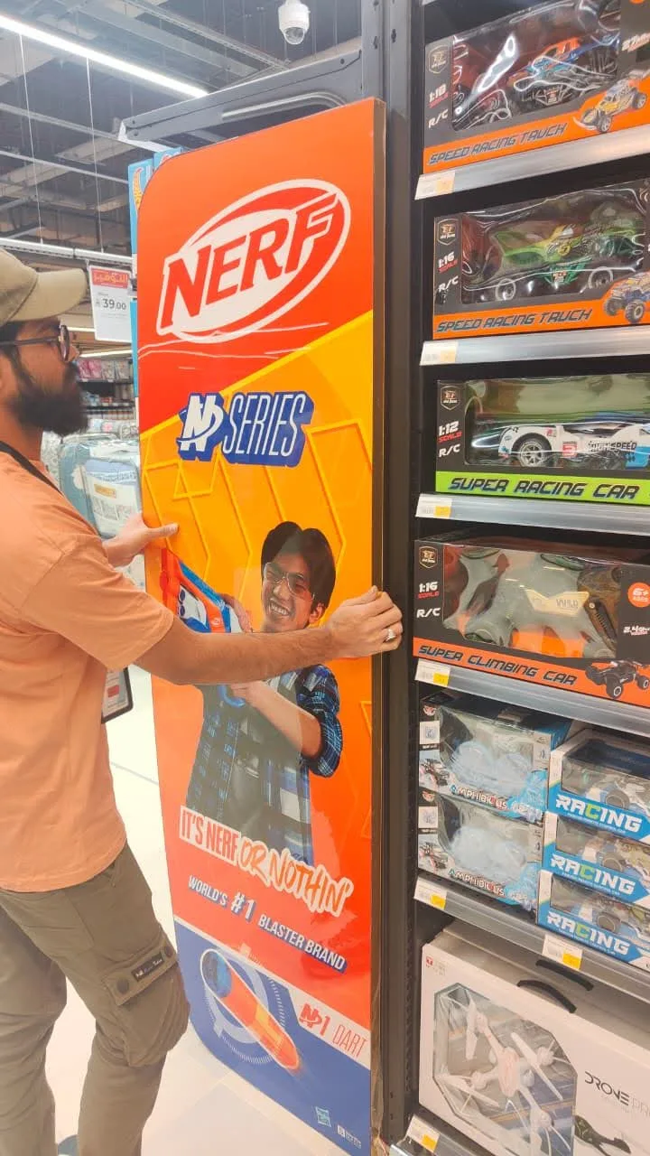 Aisle-end display graphic being fitted in a store