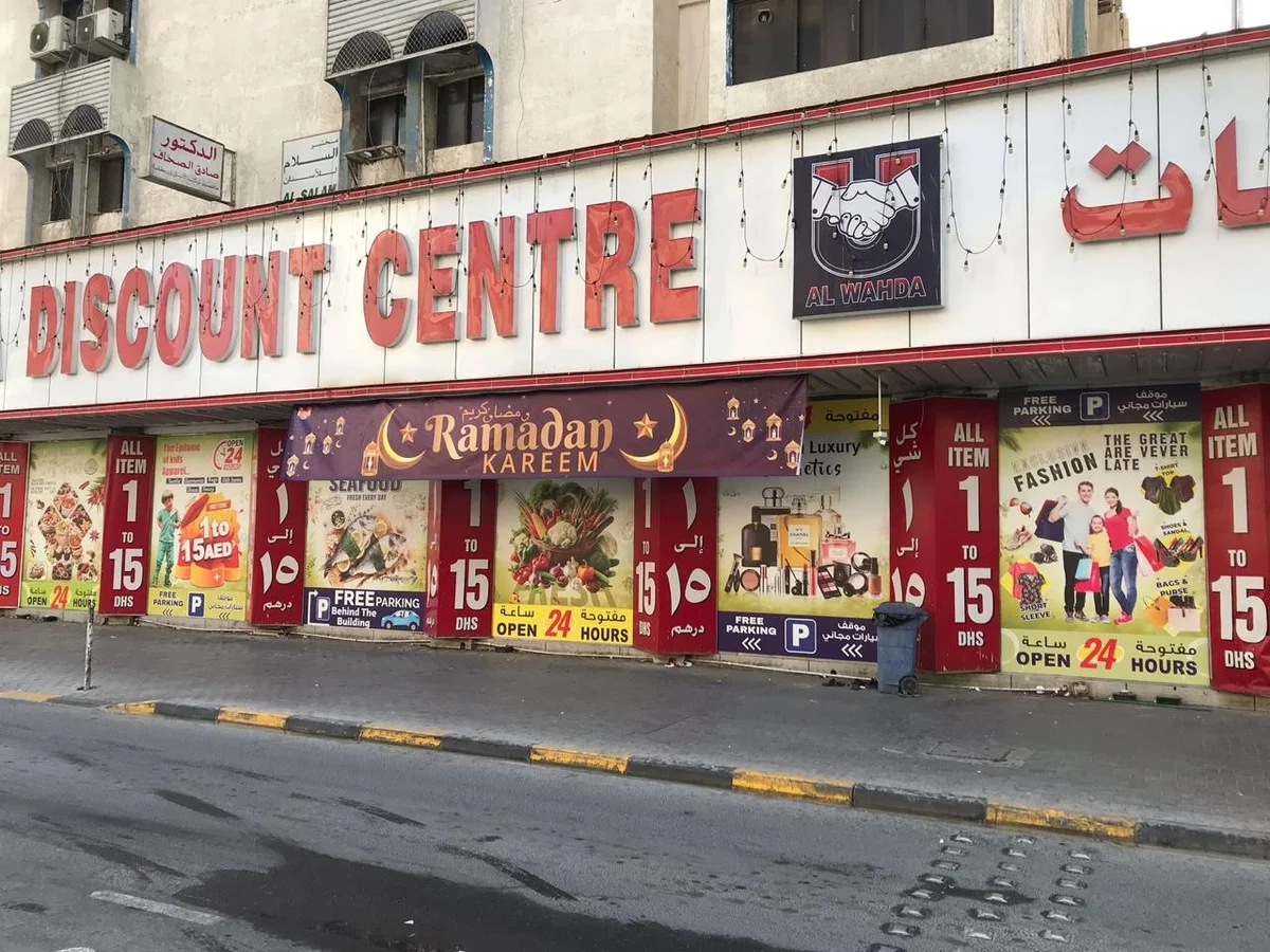 Large 3D building letters across a discount centre facade above printed window graphics