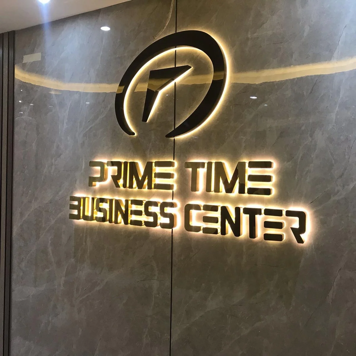 Halo-lit logo and letters on a stone wall in a business centre reception area