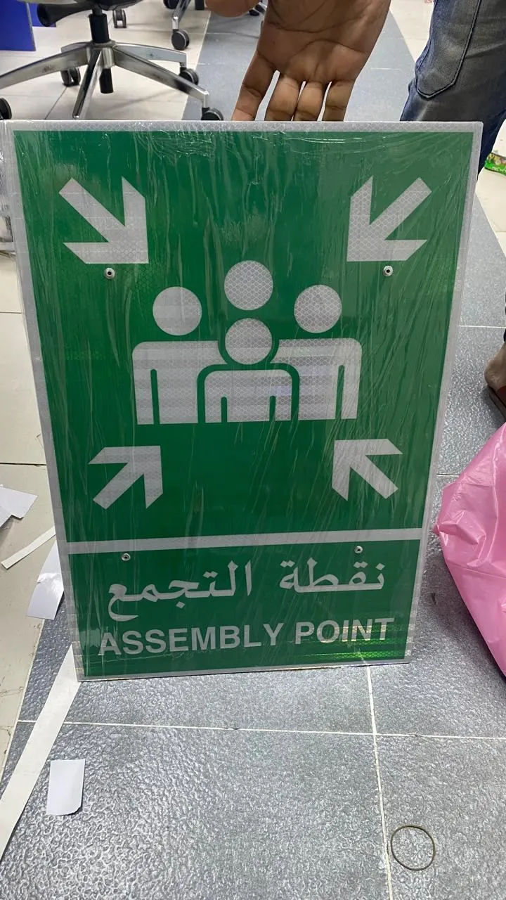 Green bilingual emergency assembly point sign made by Bayan Signage before installation