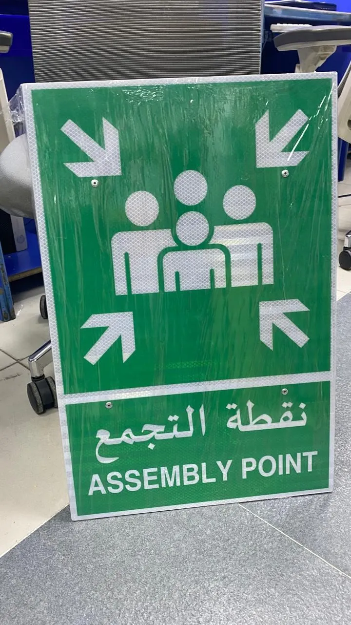 Bilingual Arabic and English assembly point sign panel produced in the Ajman factory