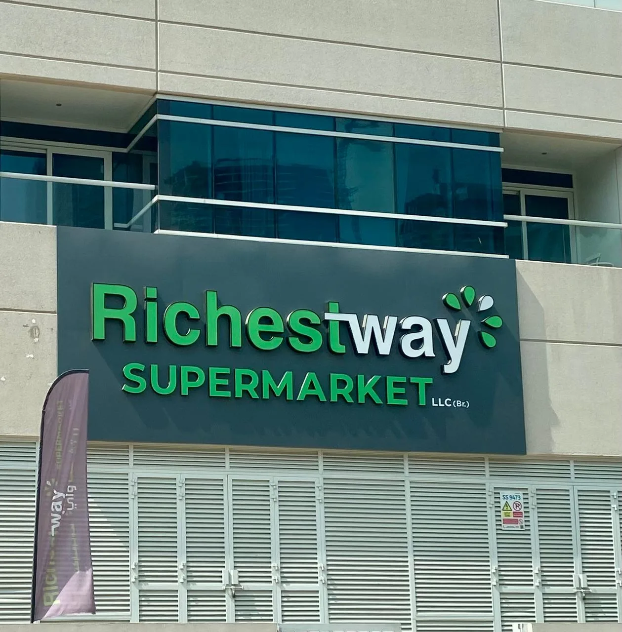 Green and white 3D letters mounted on a dark ACP fascia panel for a supermarket