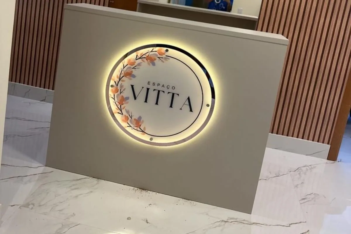 Round halo-lit backlit reception sign with company logo on a reception counter