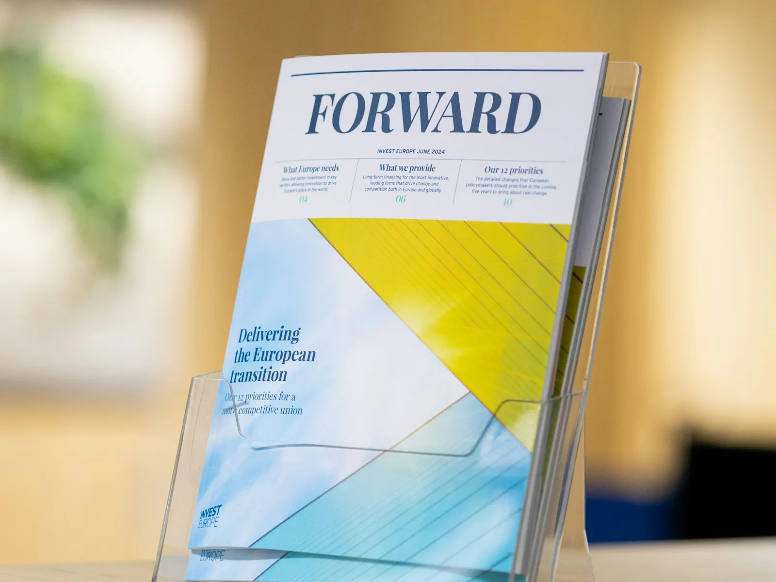 Clear acrylic brochure holder displaying a printed booklet on a reception counter