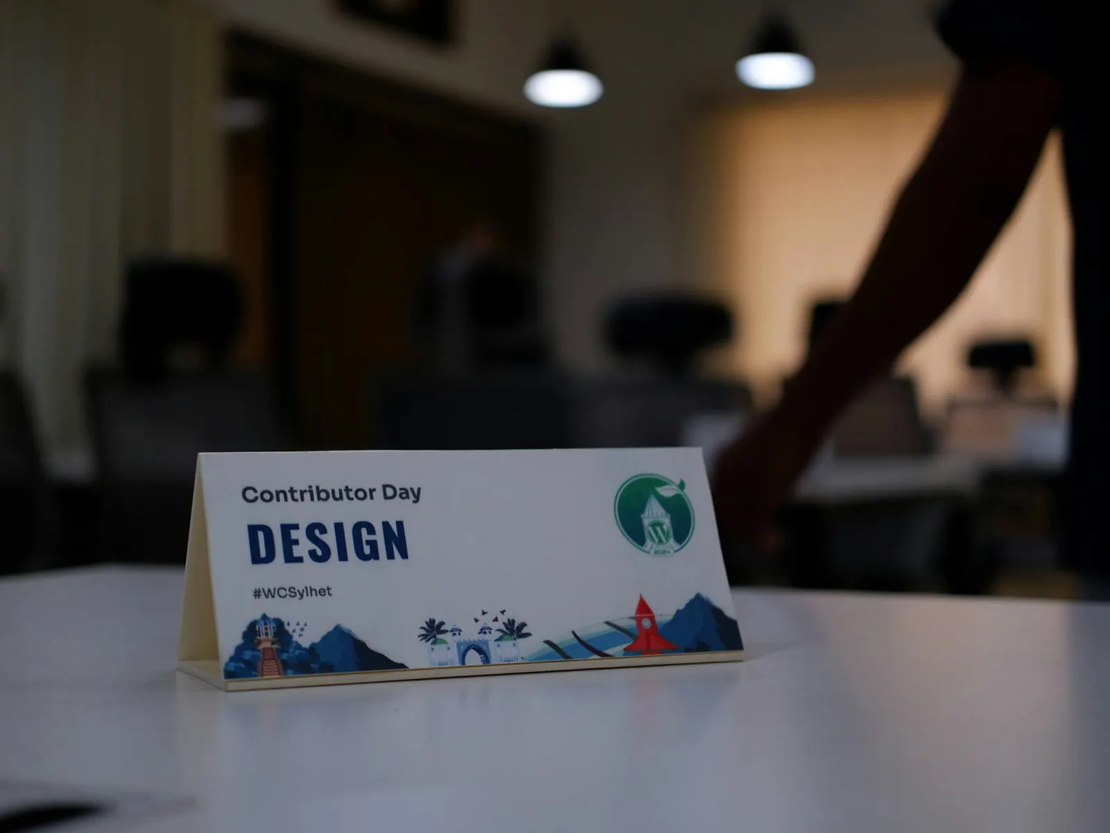 Printed tent-style desk nameplate standing on a white office desk in soft light