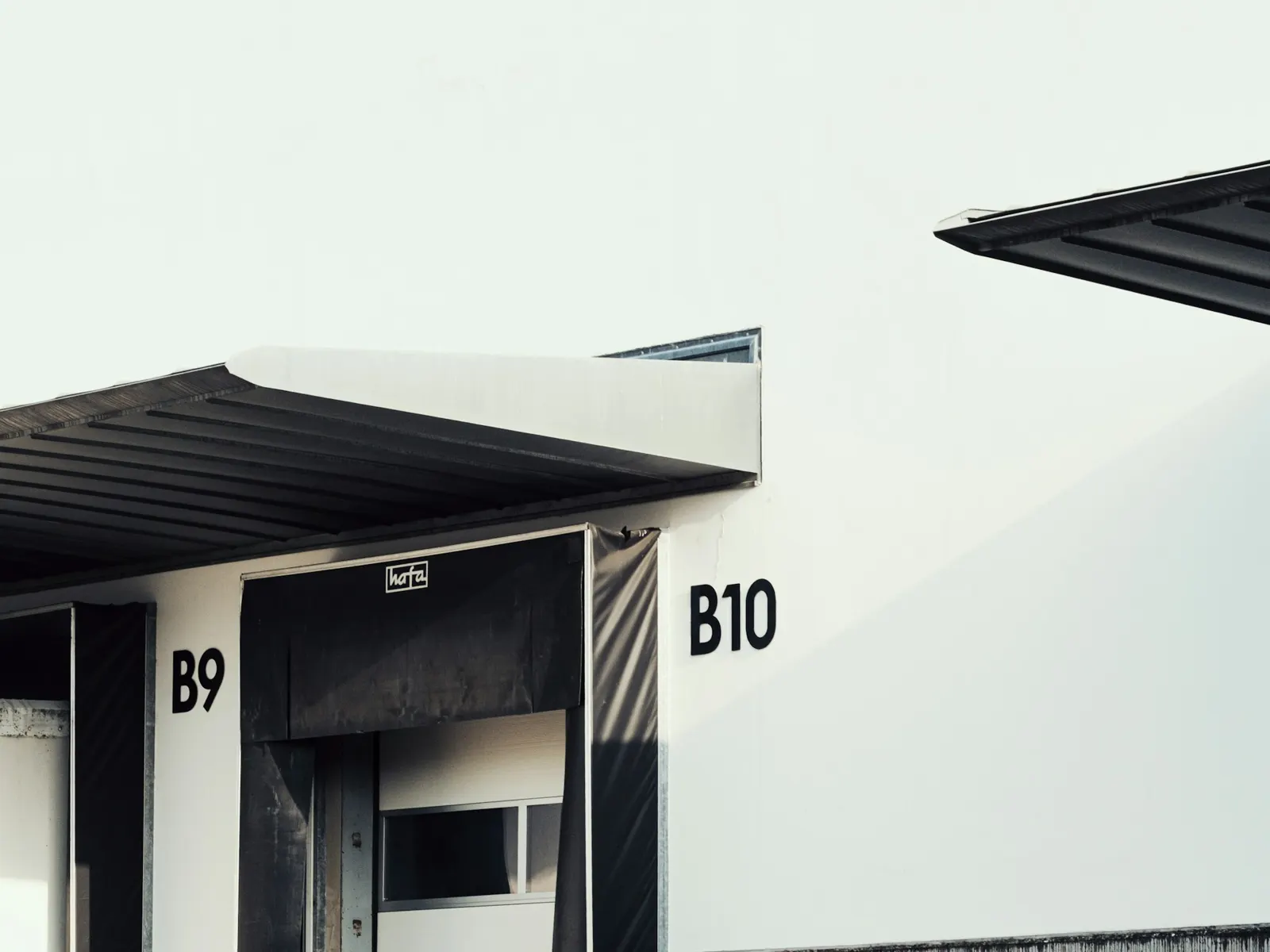 Loading dock bay numbers B9 and B10 signed above dock doors on a warehouse