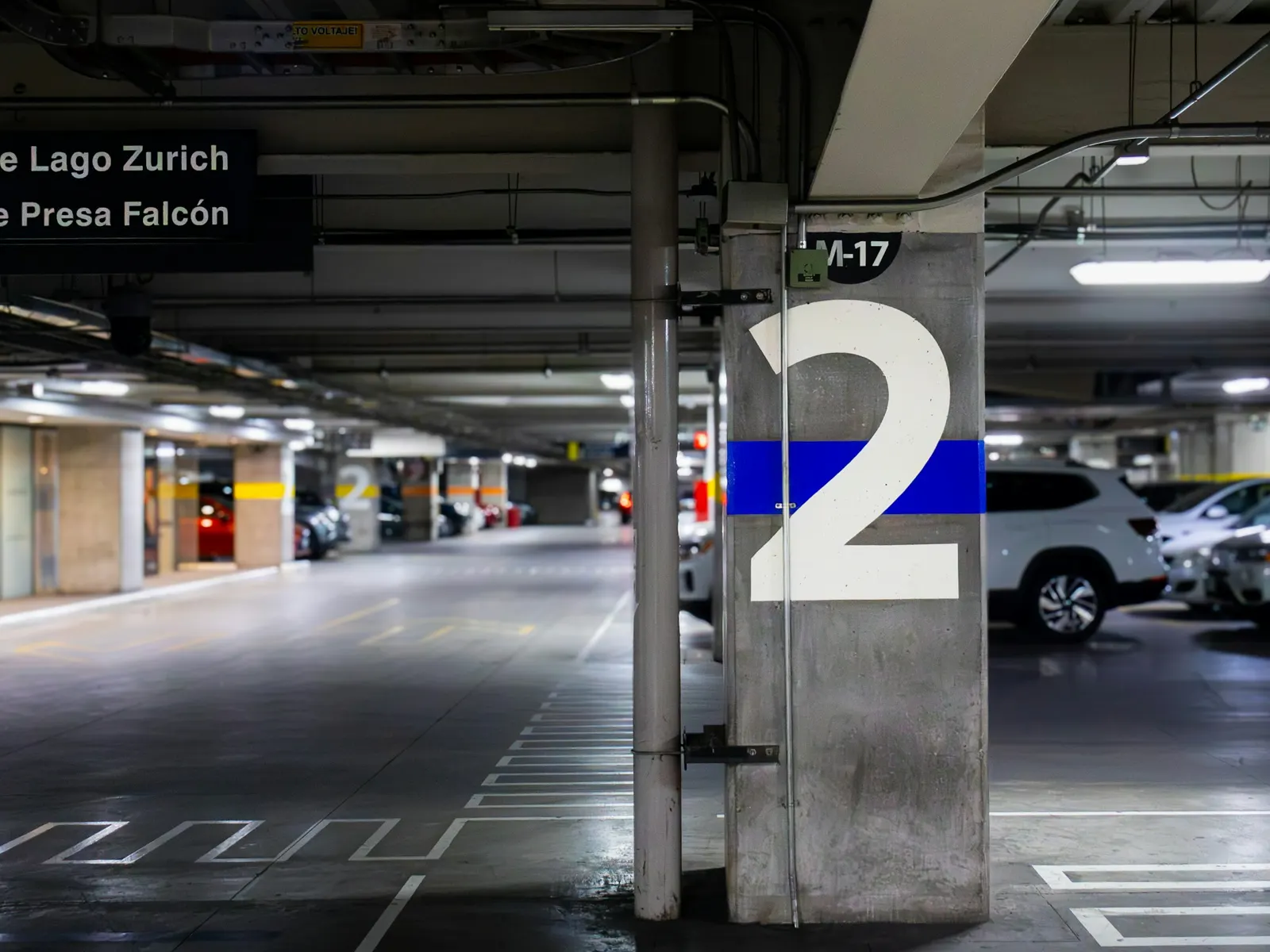 Large painted parking bay number on a concrete pillar inside an underground car park