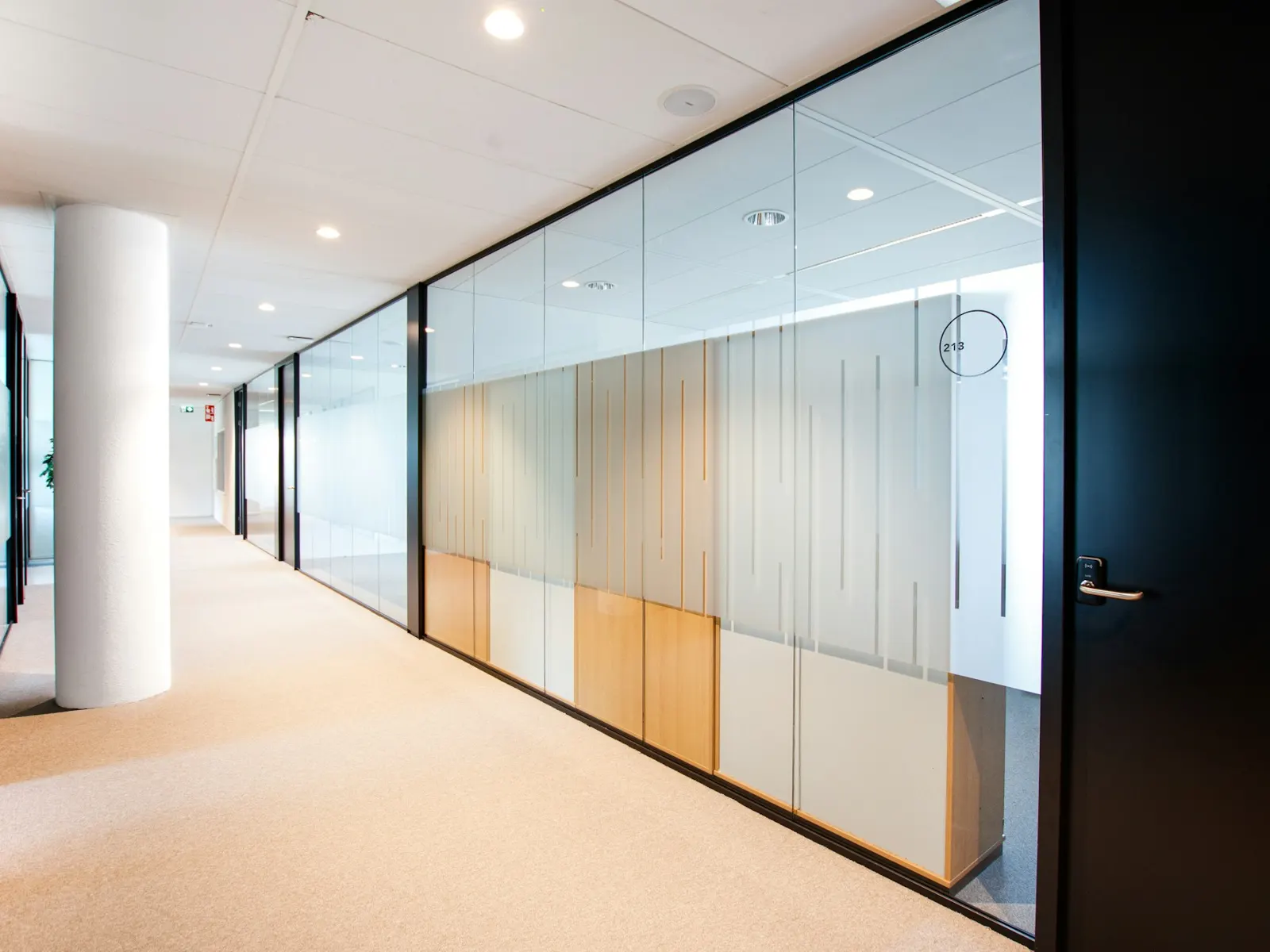 Office corridor glass partitions fitted with frosted privacy window film bands