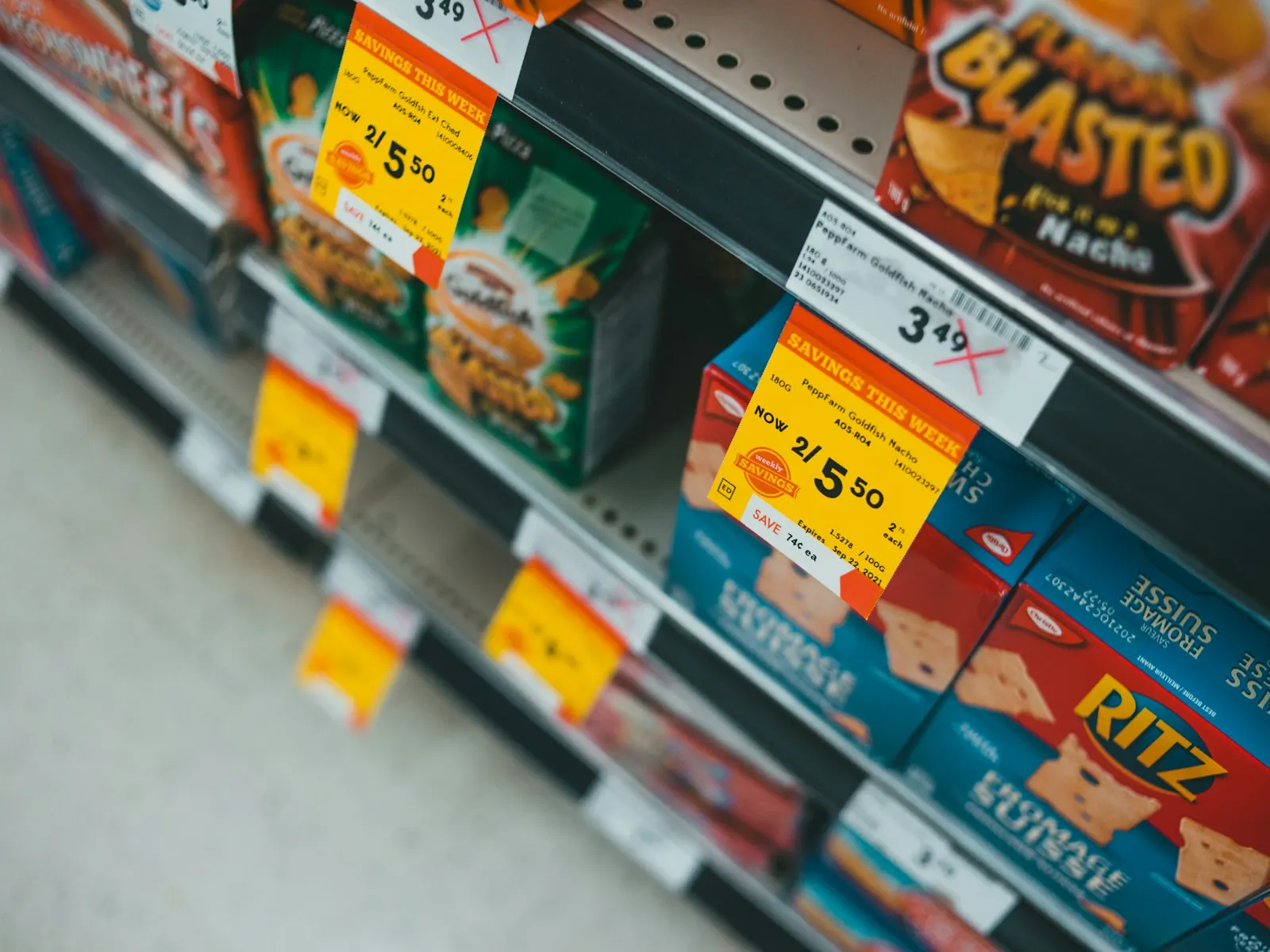 Supermarket shelves of snack boxes with yellow shelf edge price labels along the front