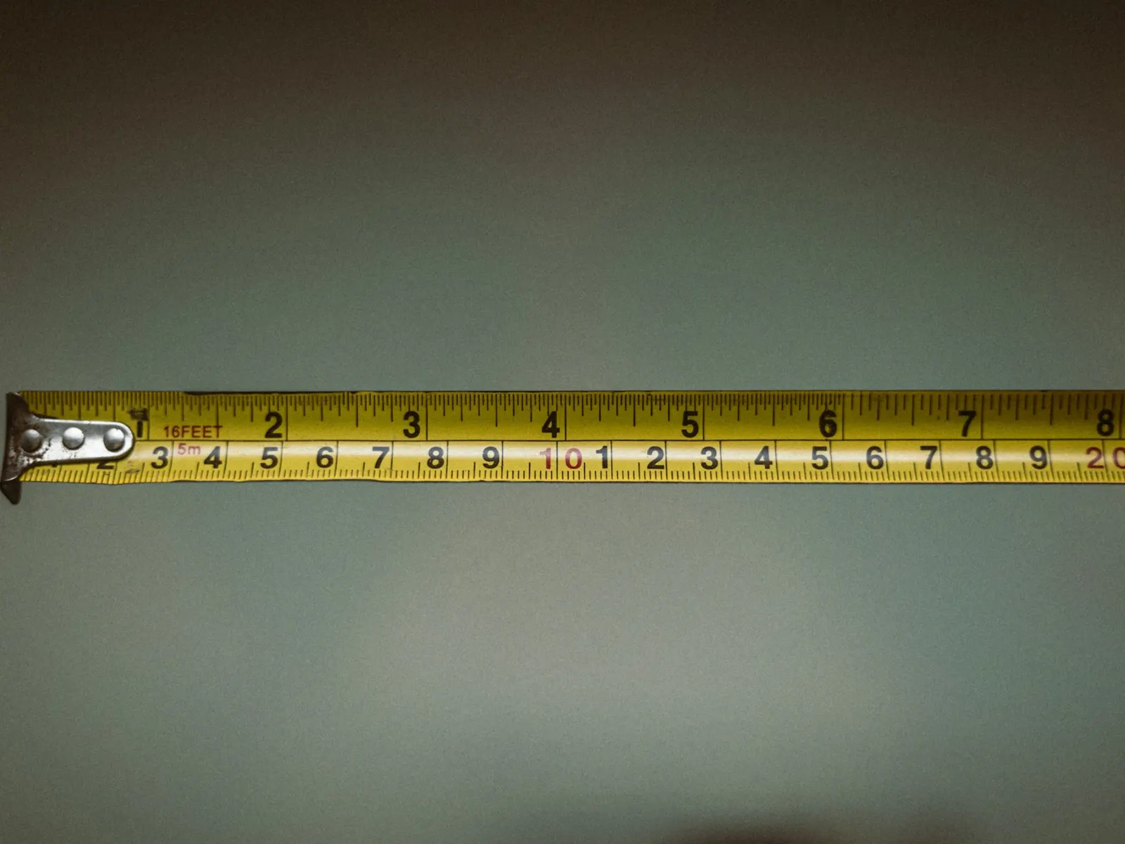 Steel tape measure blade extended horizontally to take a site survey measurement