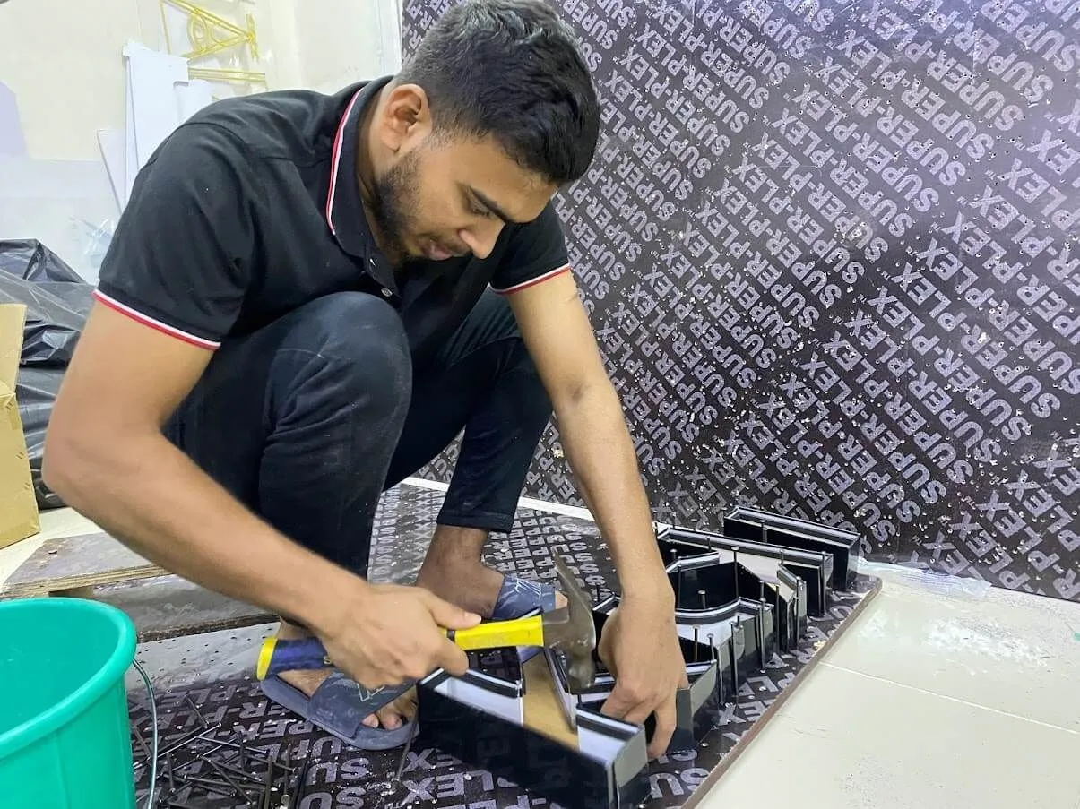 Bayan Signage technician assembling a sign in the Ajman workshop